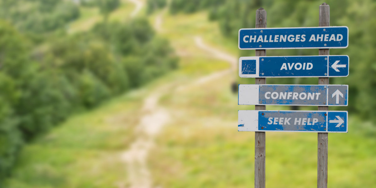 Signpost,On,Top,Of,The,Mountain,Warning,Challenges,Ahead,And Que faites-vous face à un challenge?