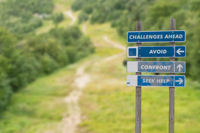 Signpost,On,Top,Of,The,Mountain,Warning,Challenges,Ahead,And Que faites-vous face à un challenge?